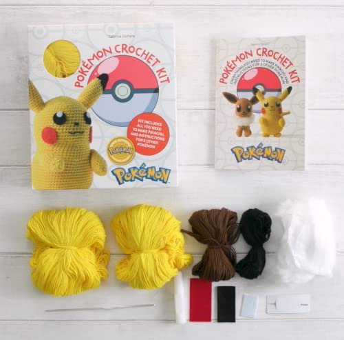 Top-down view of two PokeMon Crochet Pikachu Kits by Sabrina Somers, displayed alongside yarn in yellow, brown, and black colors, white stuffing, a crochet hook, and felt pieces on a white wooden surface.