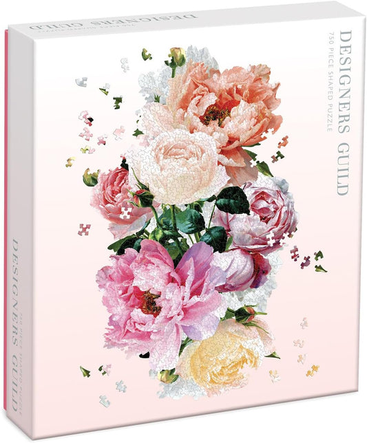 A Galison Designers Guild Tourangelle Shaped Puzzle, 750 Pieces, 16.25” x 26”, featuring a vibrant floral design with pink, peach, and yellow roses and scattered puzzle pieces against a soft pink background.
