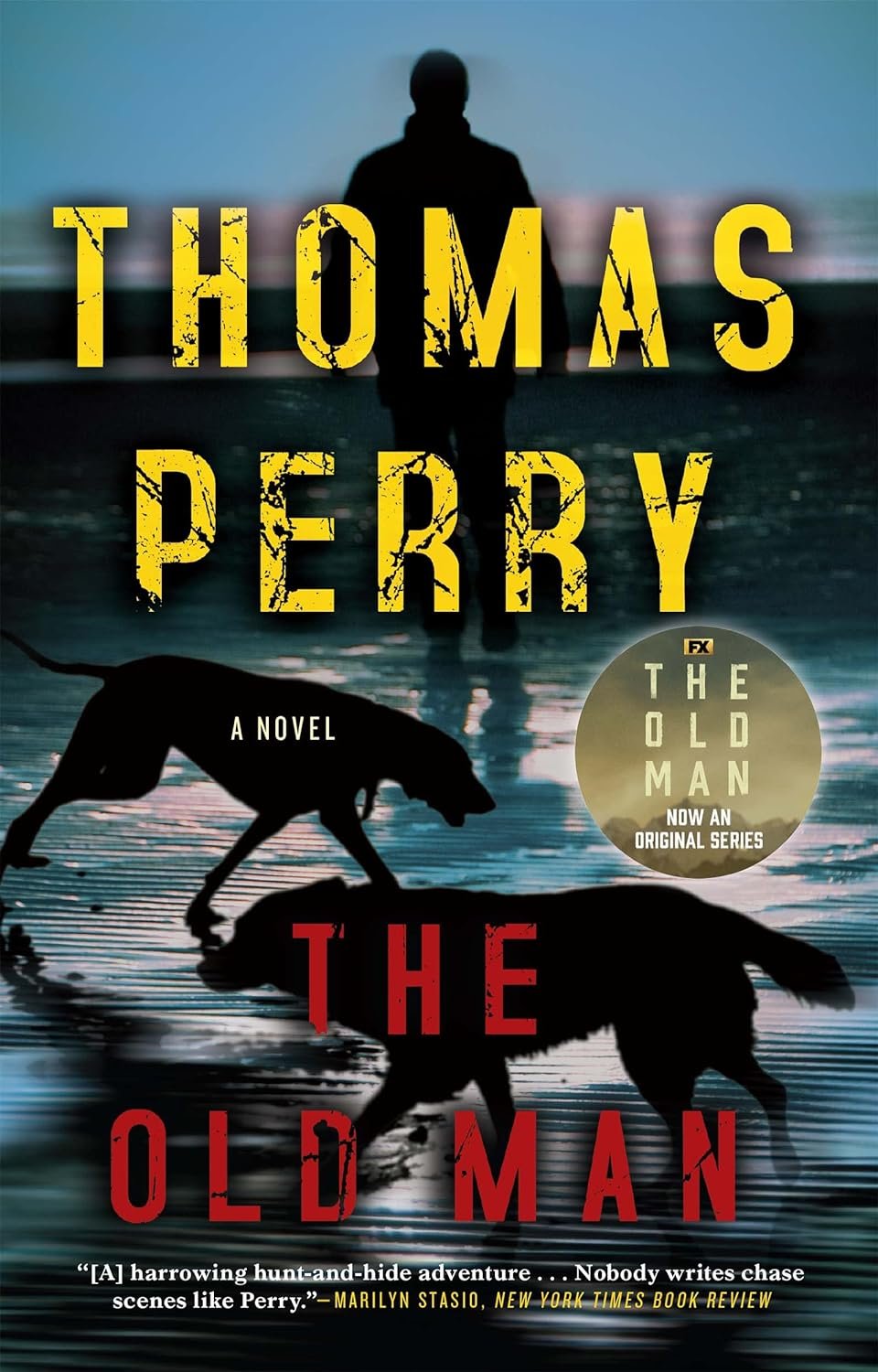 Book cover for "The Old Man" by Thomas Perry featuring a silhouette of Jeff Bridges with a dog, both reflecting on a wet surface, set against a sunset. The title is in bold yellow letters.