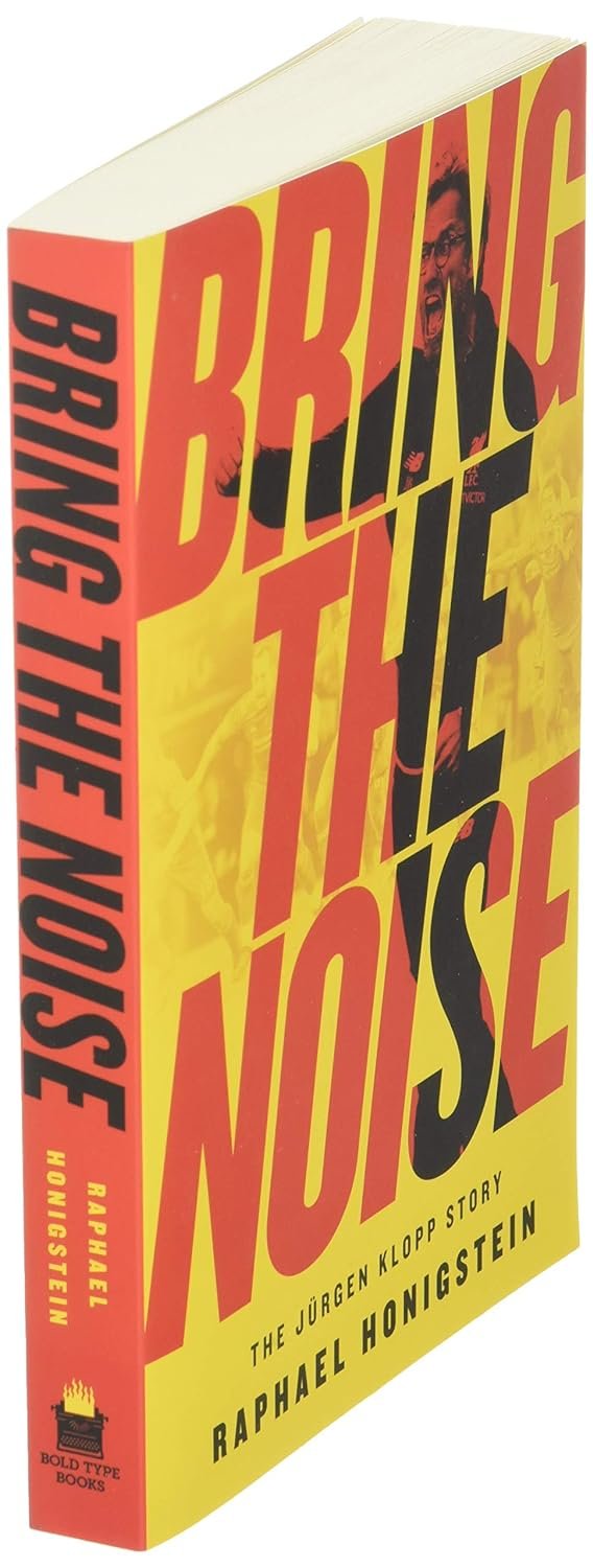 A book titled "Bring the Noise: The Jürgen Klopp Story" by Raphael Honigstein, displayed standing with the spine facing towards the viewer, featuring a yellow and red cover with images.